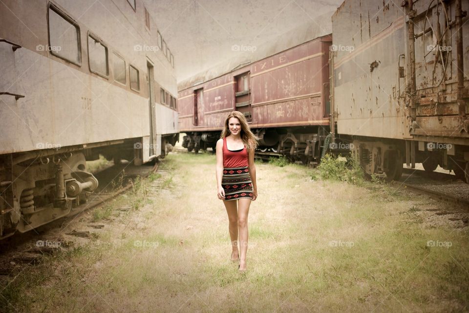 Young woman walking near railway engine