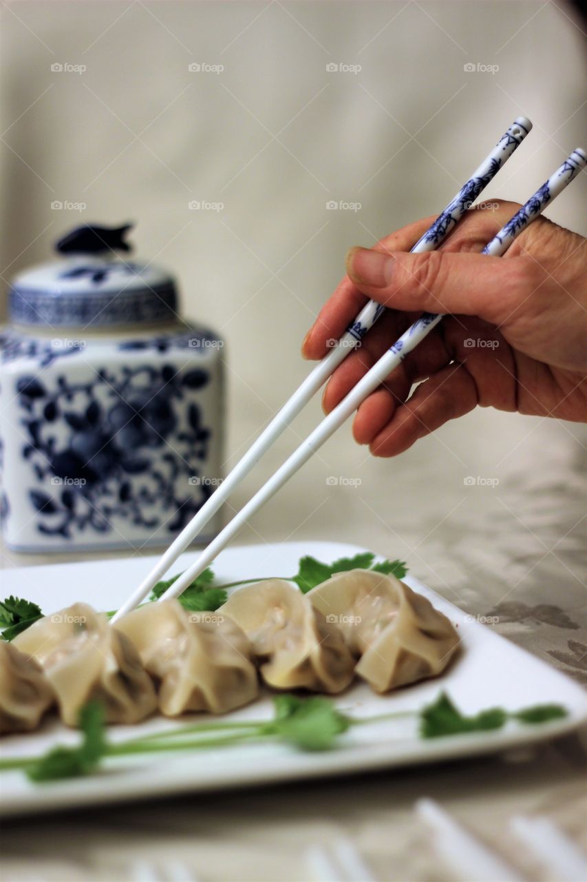 Close-up of a person hand eating dumplings