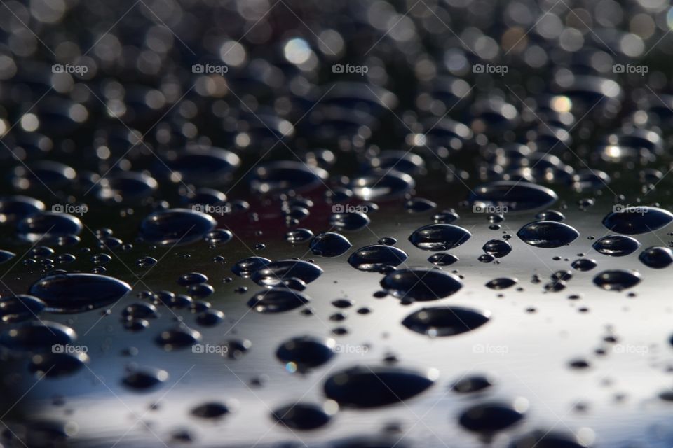 Rain beads on a black car