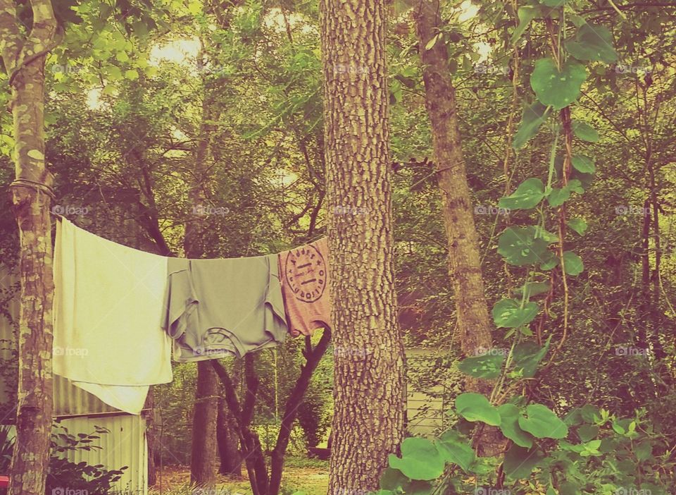 A depiction of simple living. Clothes hanging from a clothesline. Country living at it's finest.