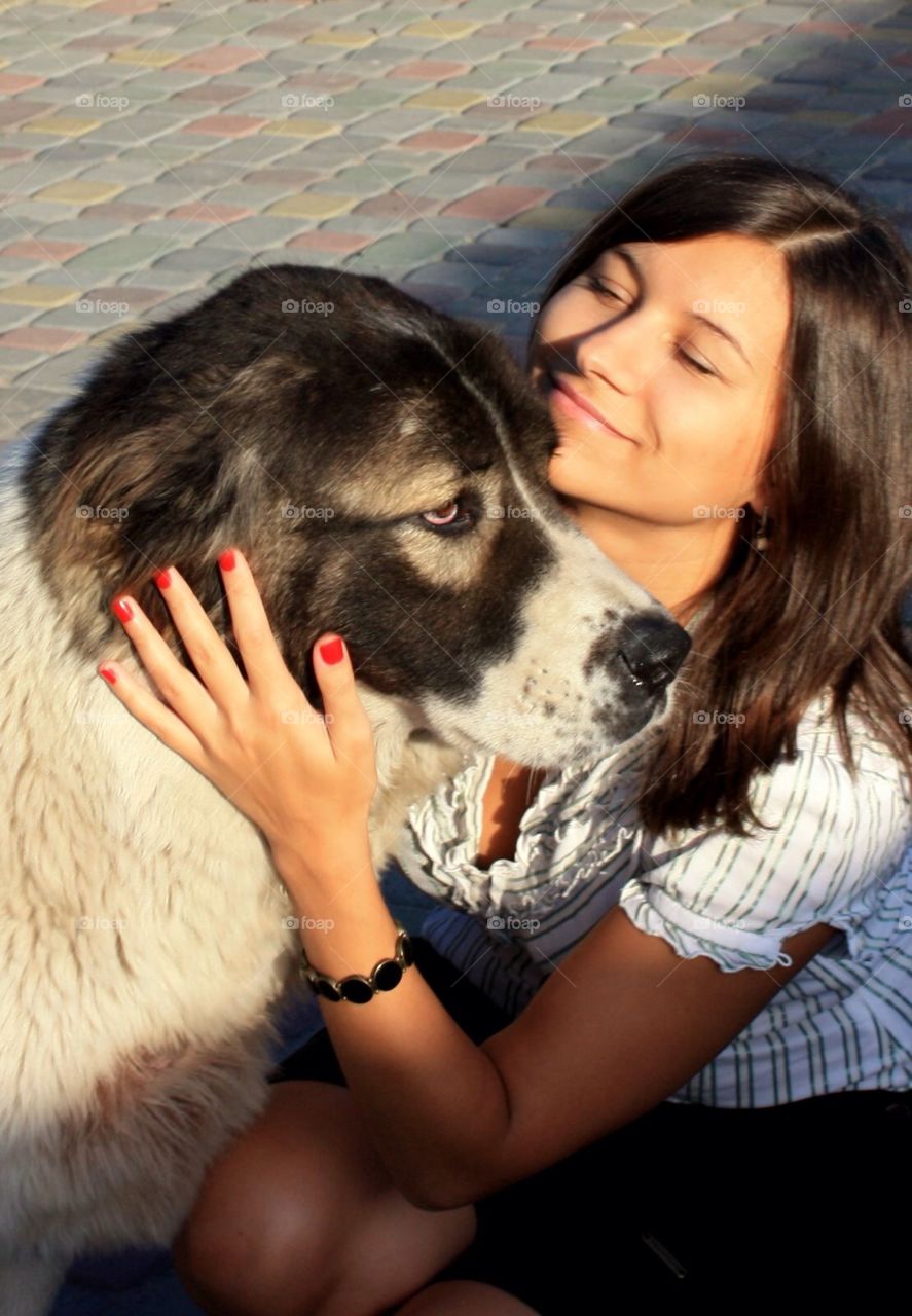 Young brunette hugging with big dog  