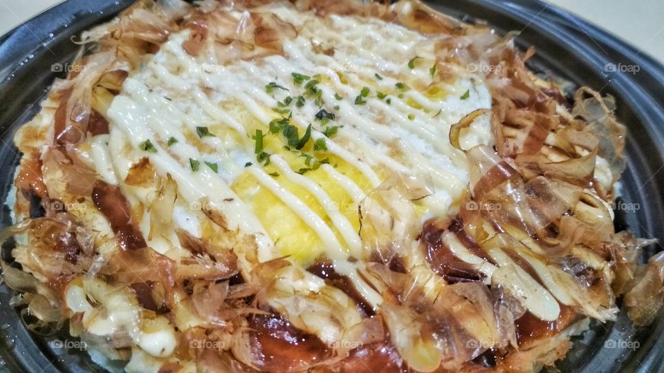 Okonomiyaki is a dish (basically a type of pancake) originated from Japan. It means ‘grilled as you like it’. It is made with flour, eggs, chicken/meat/octopus and anything would you like to put. Even nowadays also it comes with cheese topping!