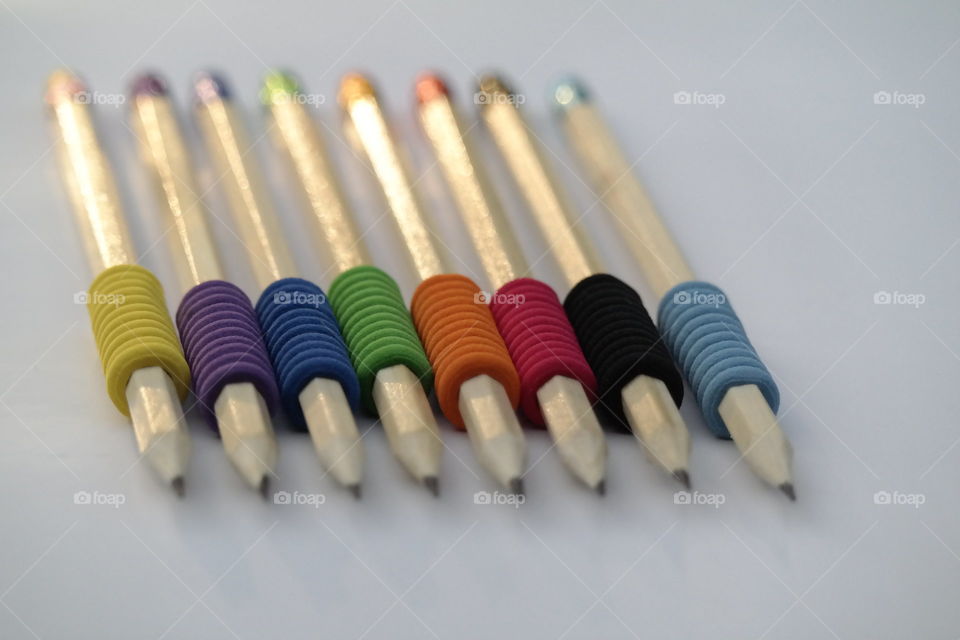 Pencils colorful erasers on white paper sheet 