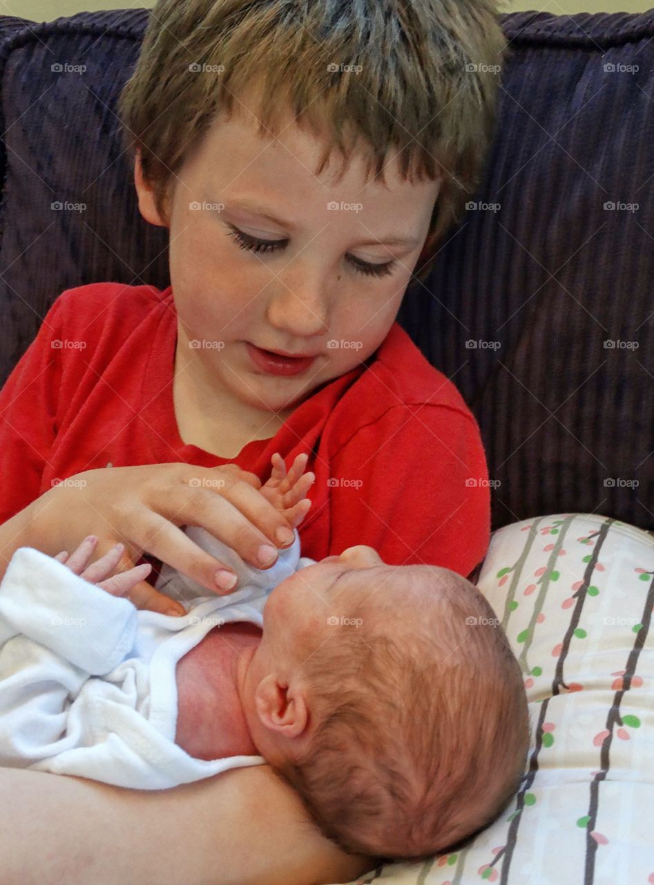 Young Boy Holding His Newborn Baby Sister