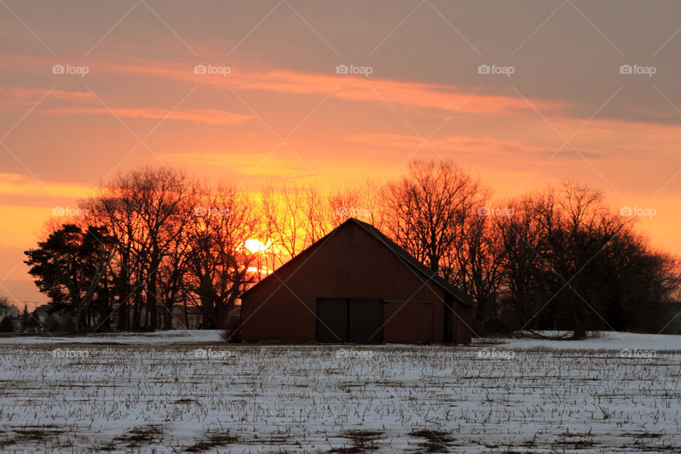 Barn in the snow during sunset