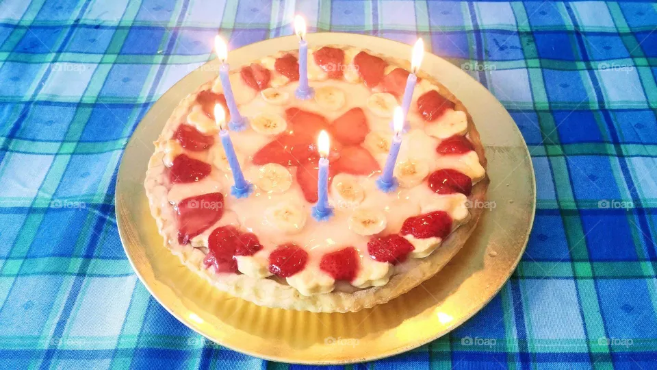Fruit birthday cake with strawberries & bananas and candles