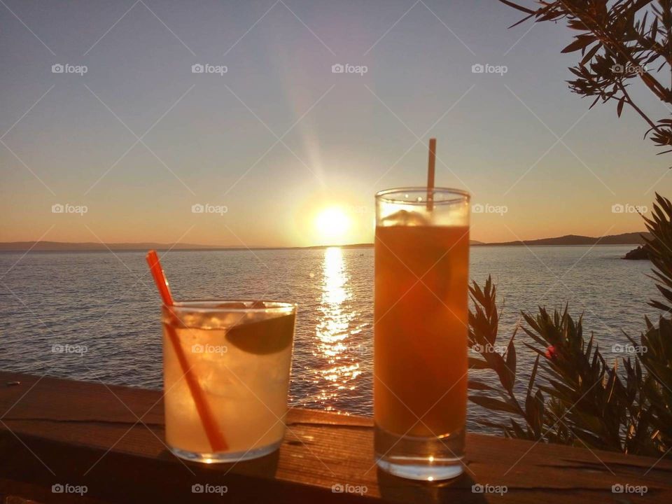 Having a cocktail, relaxing and watching the wonderful sunset of Chalkidiki, Greece. Summertime and the living is easy.