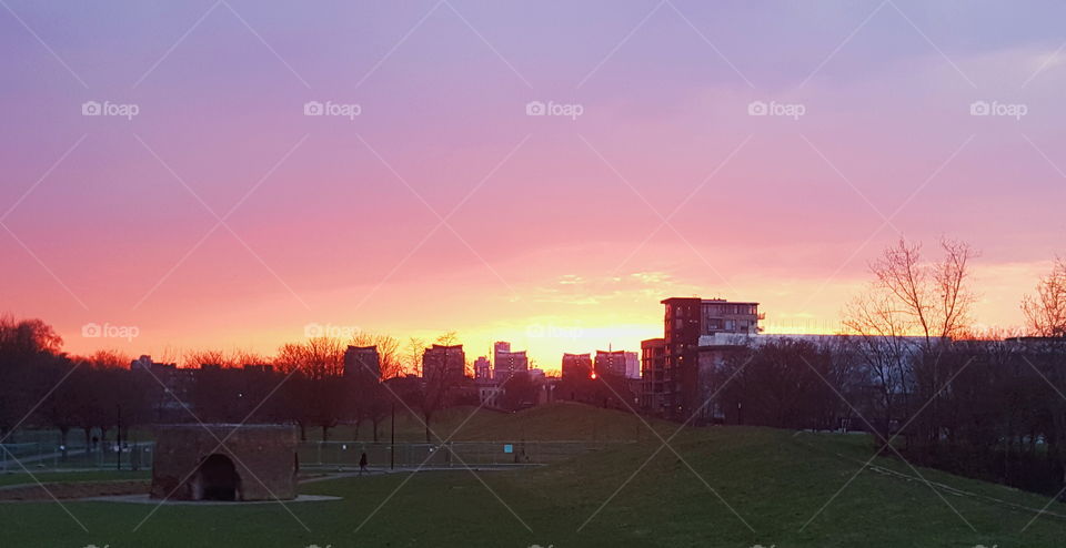 Colourful sunset over city buildings.
