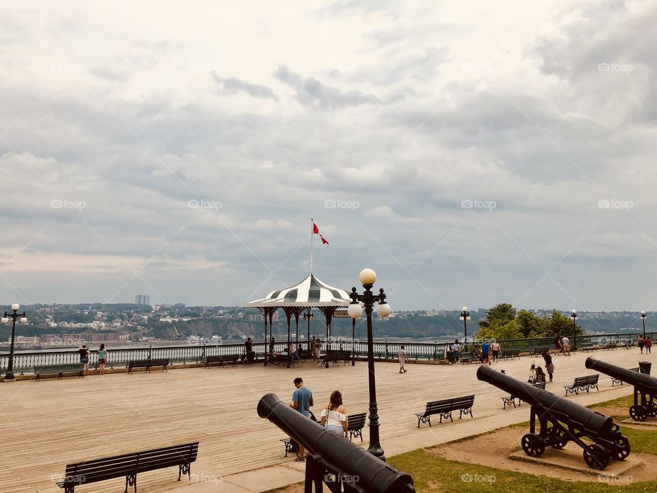 Pier along St Laurent River in Quebec city, cloudy day, lots of benches and old cannons
