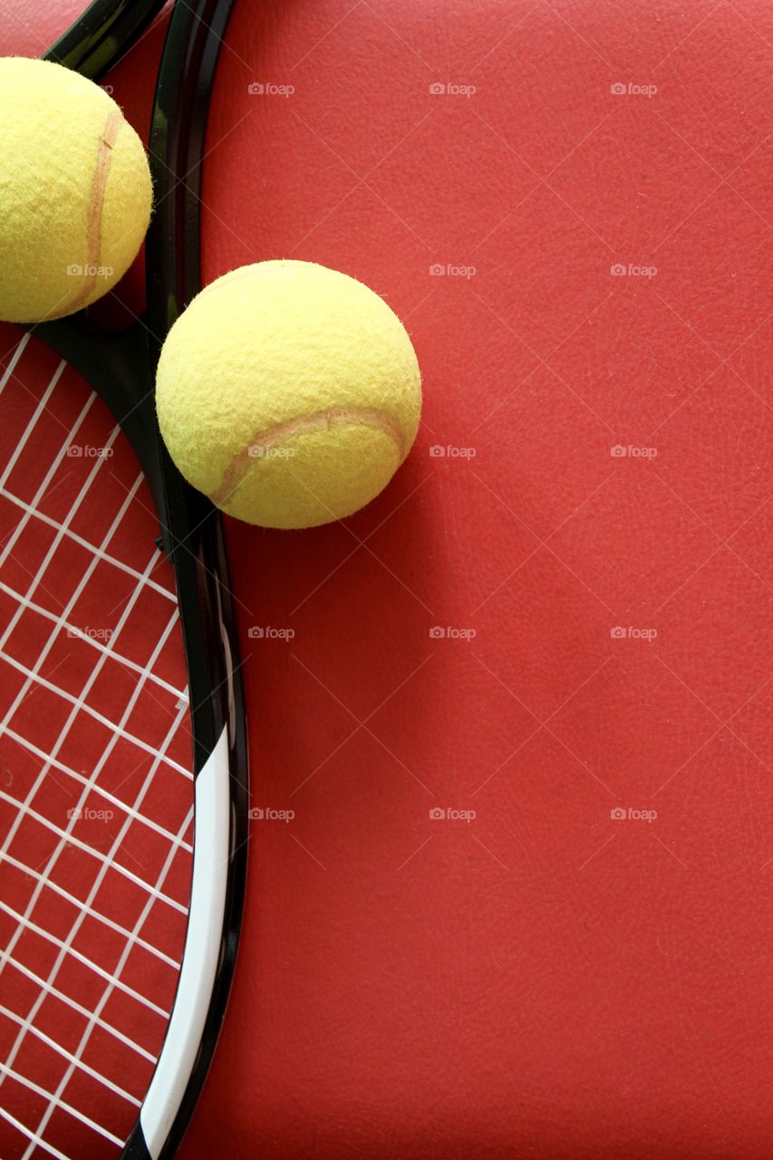 Racket and tennis balls on red background