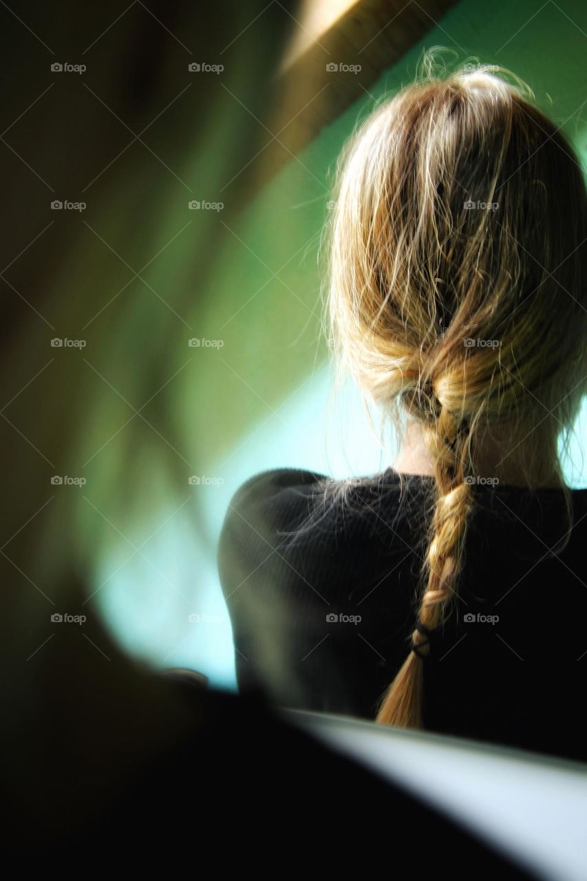 Rear view of a woman with red braided hair  in the mirror