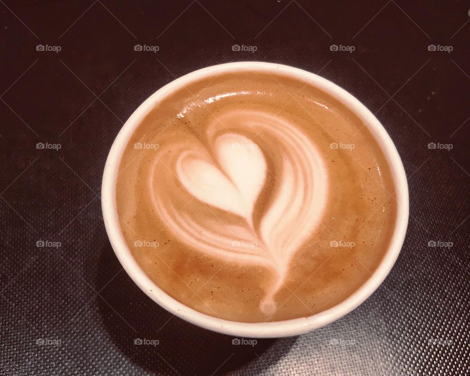 Coffee cup on the table. Latte art. Brown and white colors, dark background. Latte art heart! Coffee photo