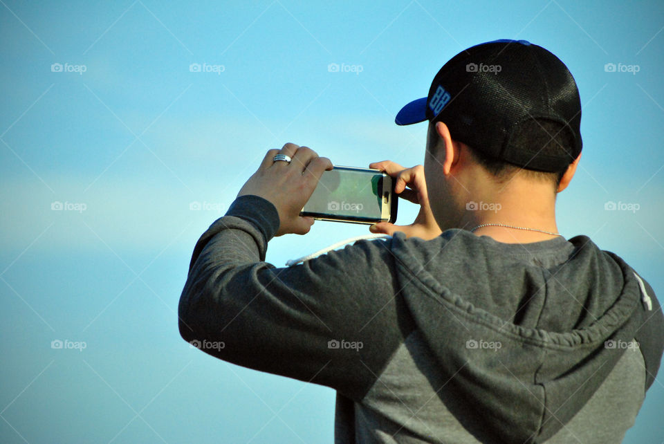 man using mobile phone as camera