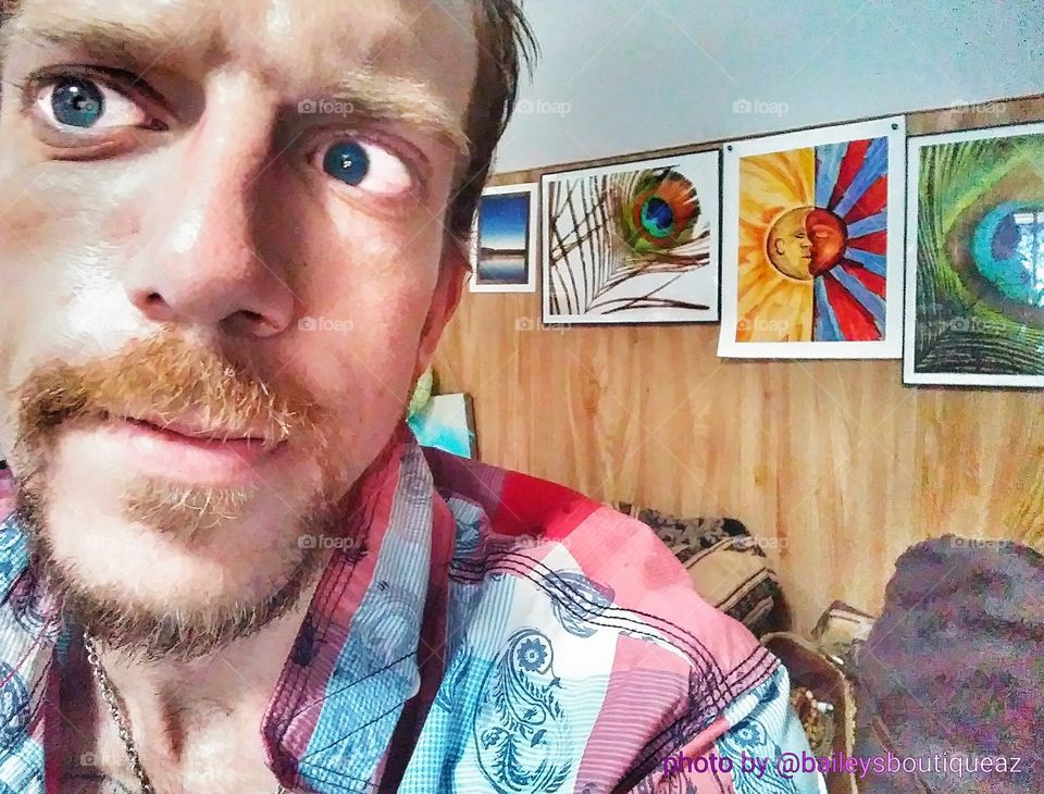 Selfie Taken Inside with Artwork Hanging on Wall in Background with Famous Peacock Plume Picture and Yin Yang Sun and Moon Art by Ben Underwood