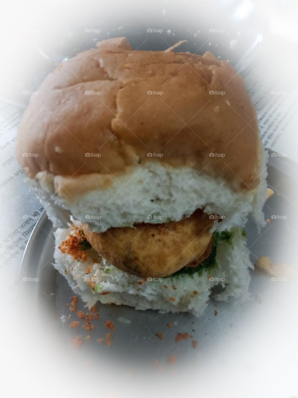 "Vada Pav" The famous street fast food of Mumbai, India. The dish contains a deep fried potato dumbling placed inside a bread bun (pav) sliced almost in half through the middle. It is generally served with chutneys and a green chilli.