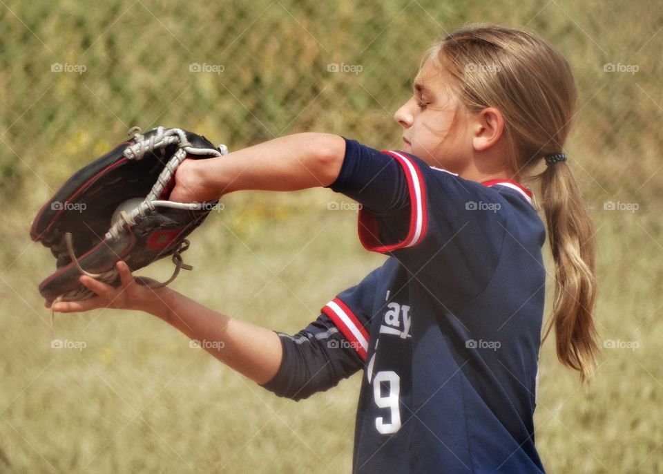 Girl Playing Baseball. Young Girl Playing American Little League Baseball
