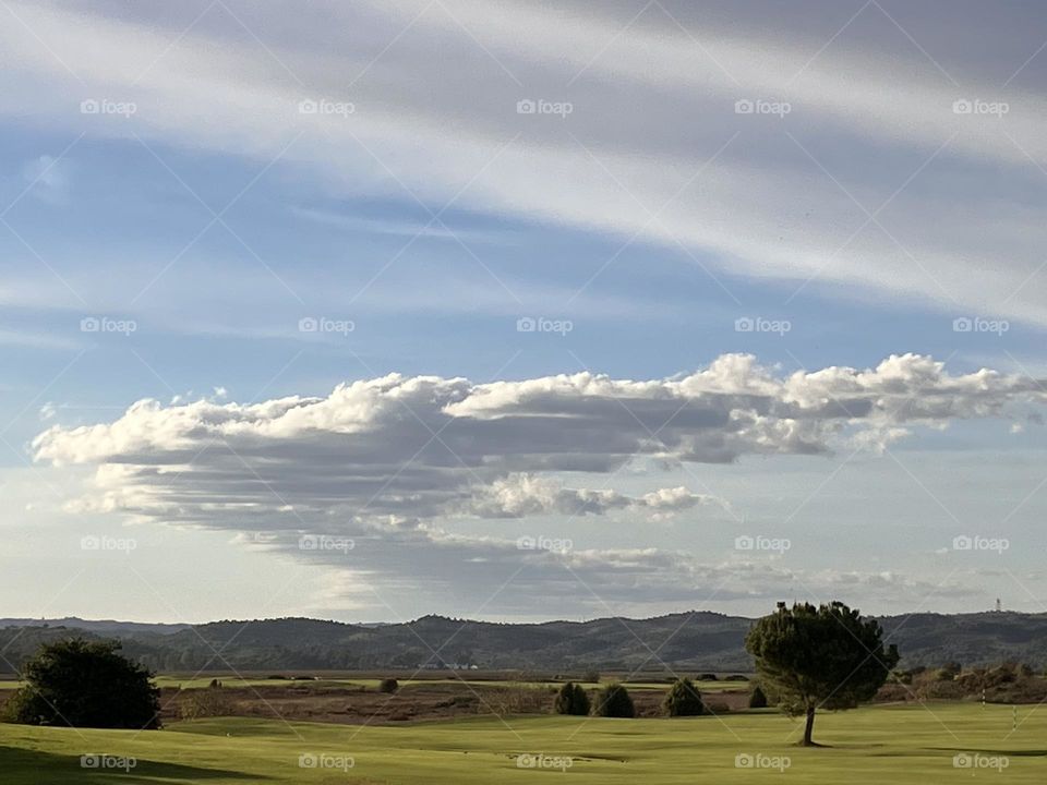 Shapes in clouds over landscape 