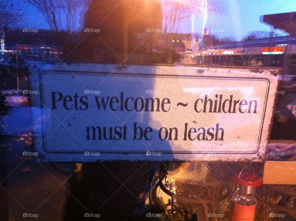 Funny Sign in Storefront. A sign in a storefront window: "Pets welcome--children must be on leash."