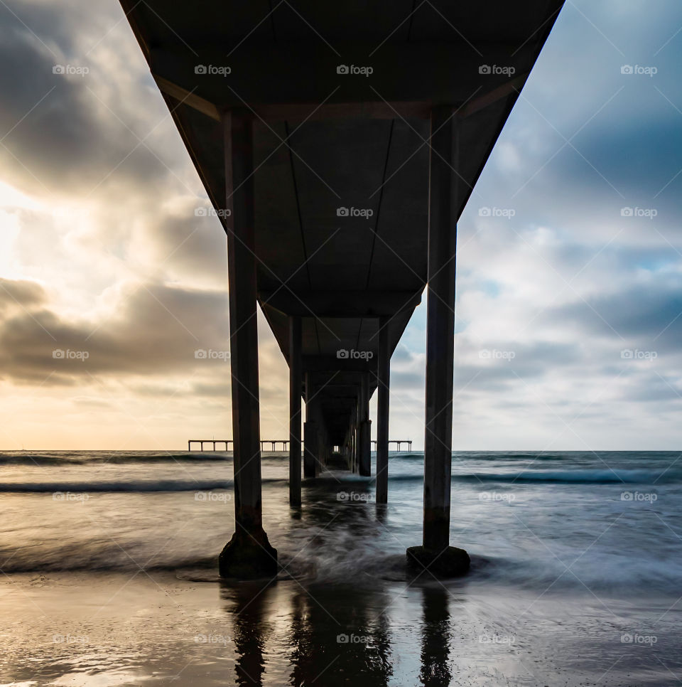 symmetry in contrast. two toned sky as the sun starts to set over the pier.