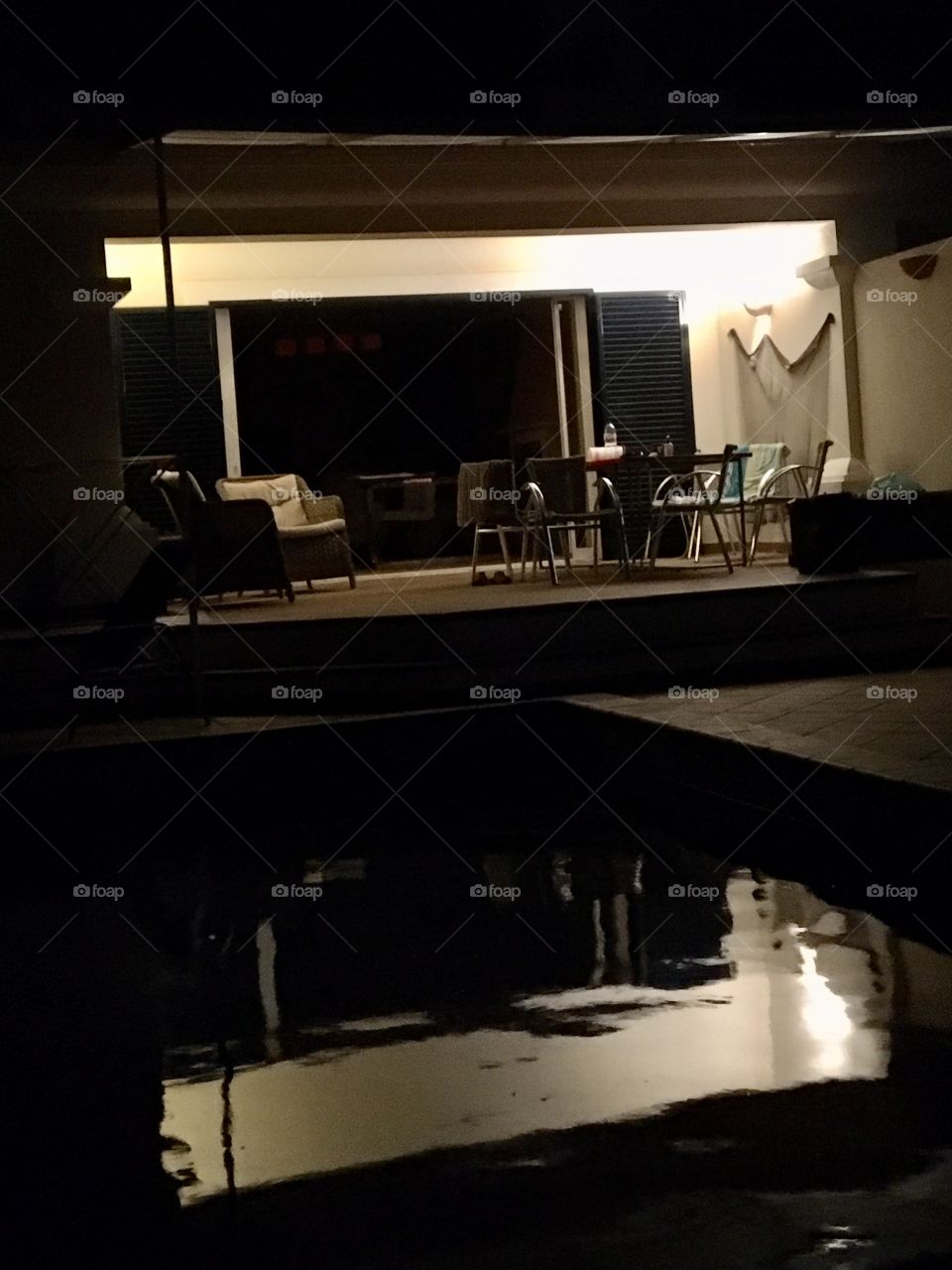 House, terrace and swimming pool by night