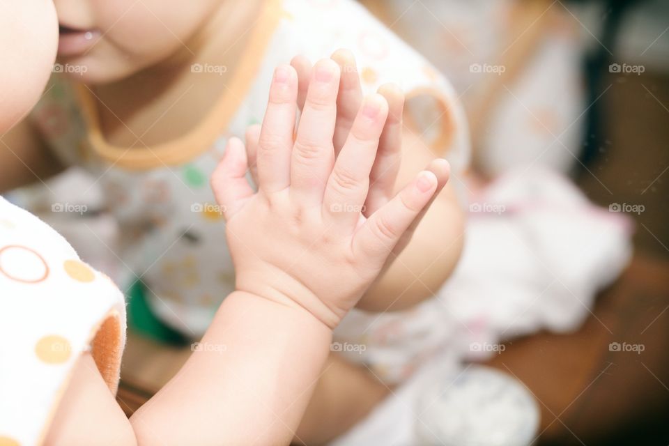 Baby looking at herself in mirror