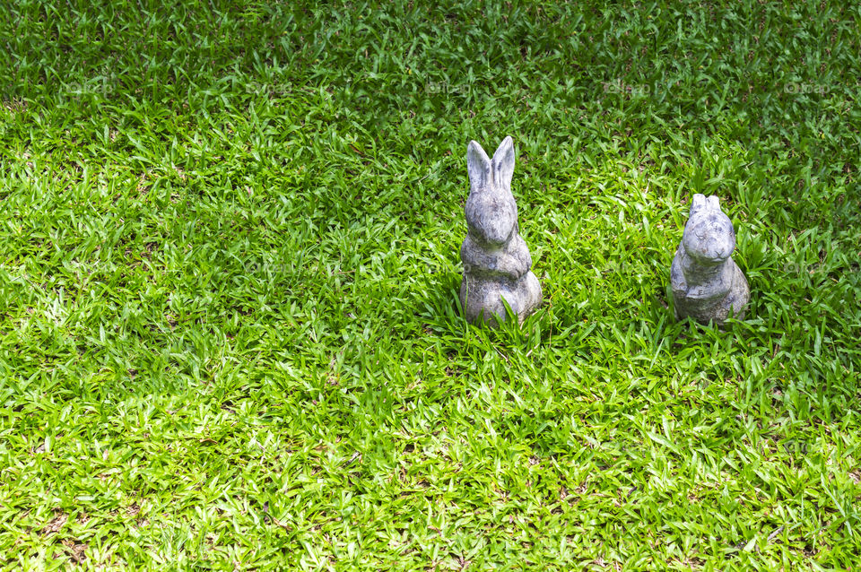 Two rabbit statue on green grass