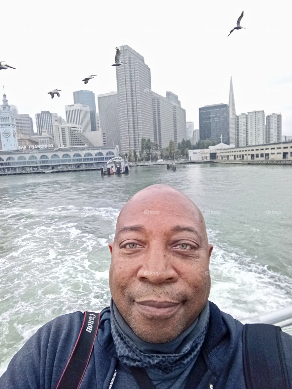 selfie pic, on the ferry headed to Pier 1 in San Francisco with pelicans flying in the background