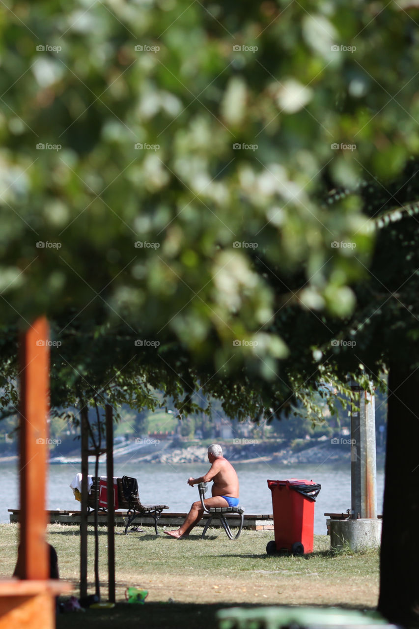 Older man enjoying sun sitting on the bench