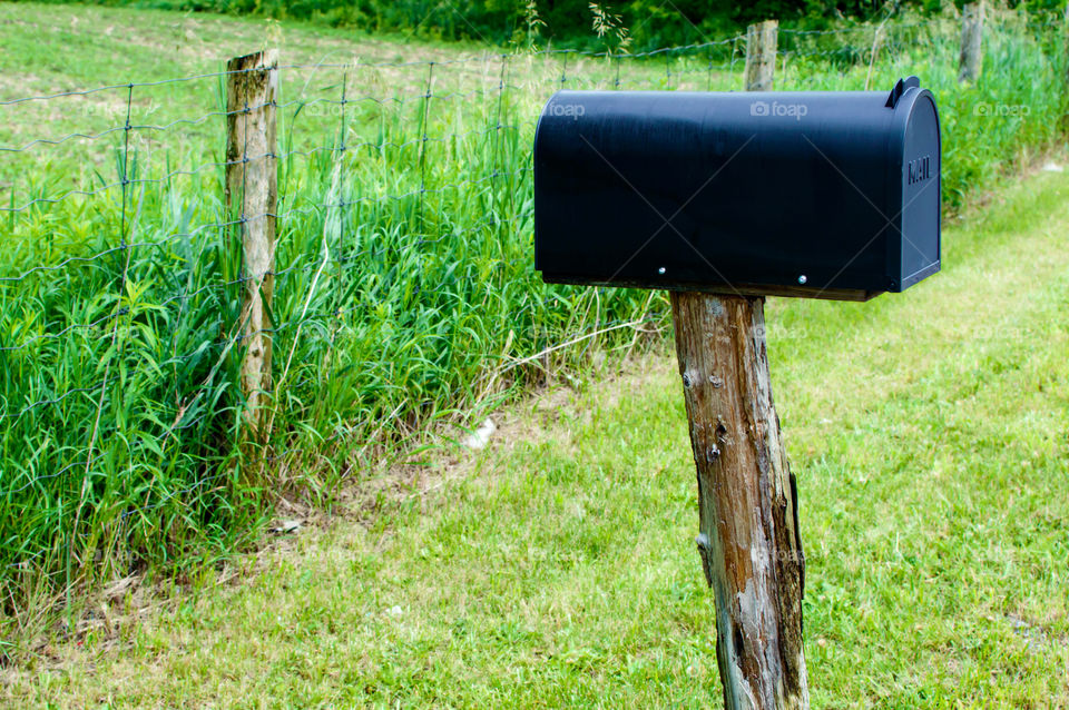 Old fashioned mailbox on deteriorating wooden post weathered and old vintage country lifestyle photography background 