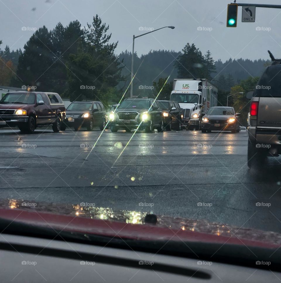 view from a red car of early morning commuter traffic headlights through the dark rainy sky in Oregon