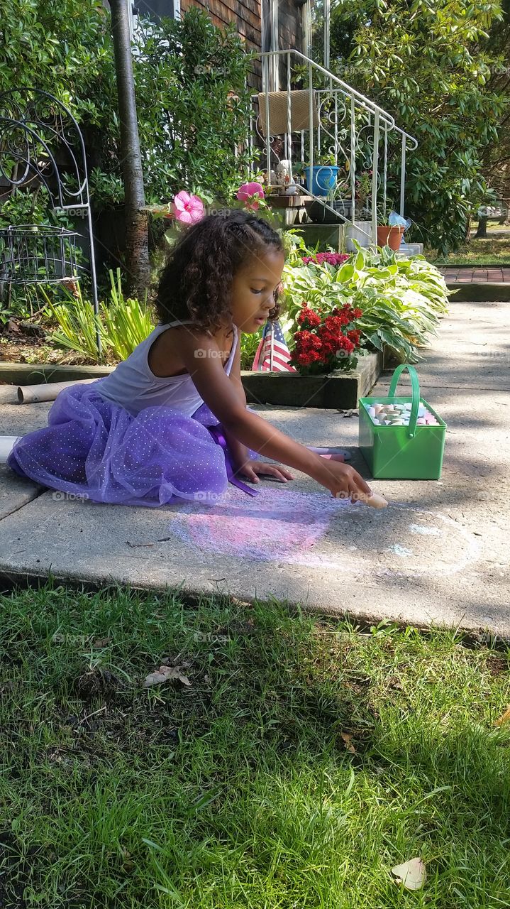 Little girl drawing on in yard