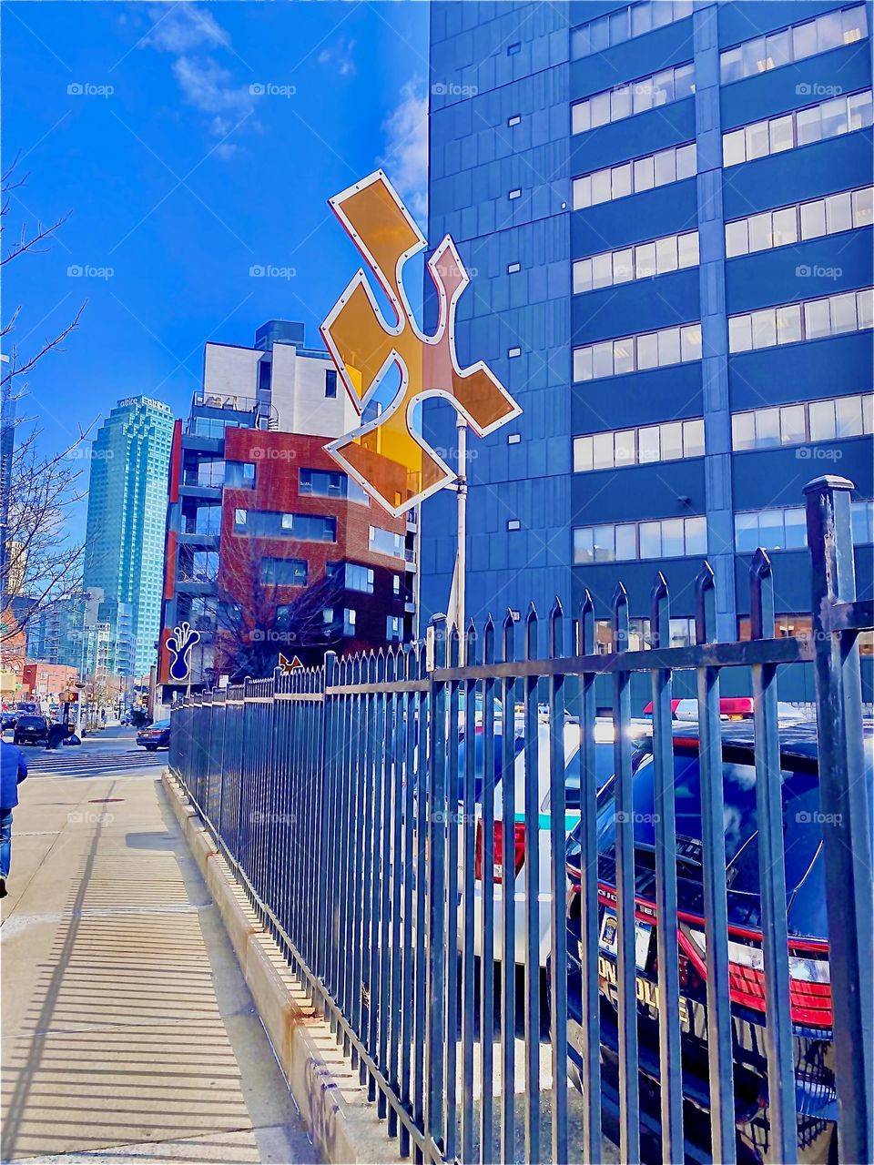 The actual art object that cast the illustrious elegantly shaped imprint upon the sidewalk somewhere near “Vernon Jackson Ave” in LIC, Queens, NY. It is attached to a pole protruding from this city fence. 2022. Hypnotic Productions