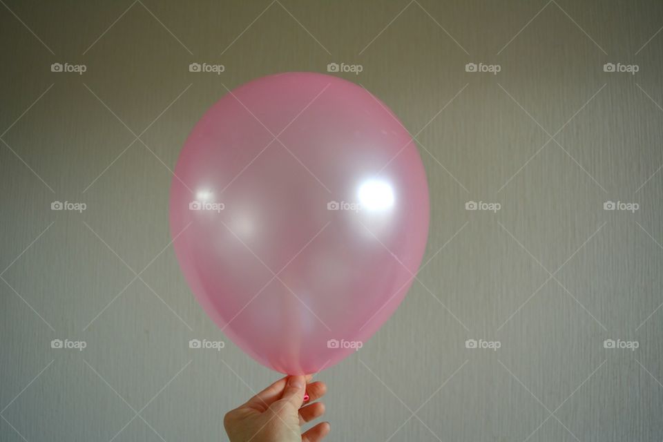 Person holding pink balloon