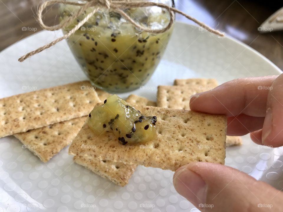 Homemade Kiwi jam and crackers on a plate 
