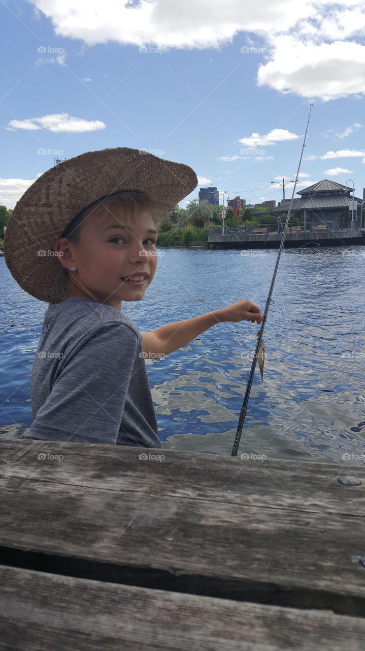 boy wearing hat fishing