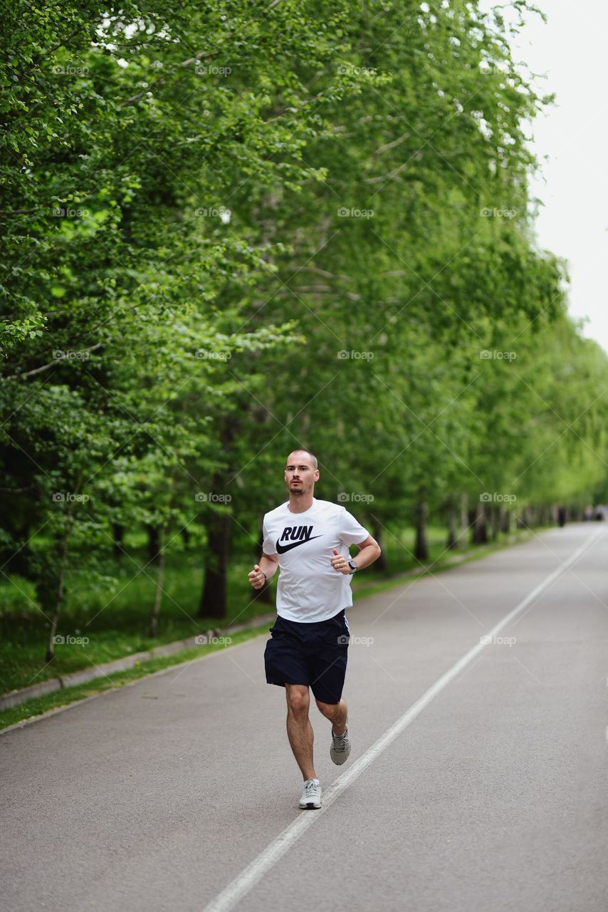 Man running through a park lane