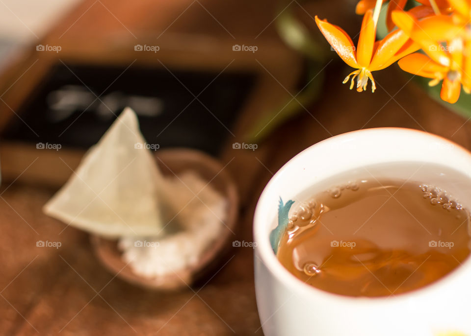 Closeup cup of energizing green tea on table with flowers  