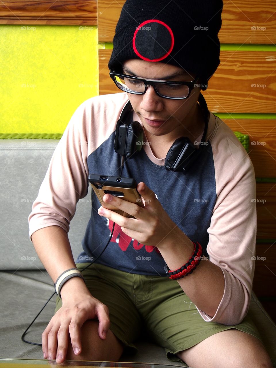 teenage boy wearing bonnet using a smartphone