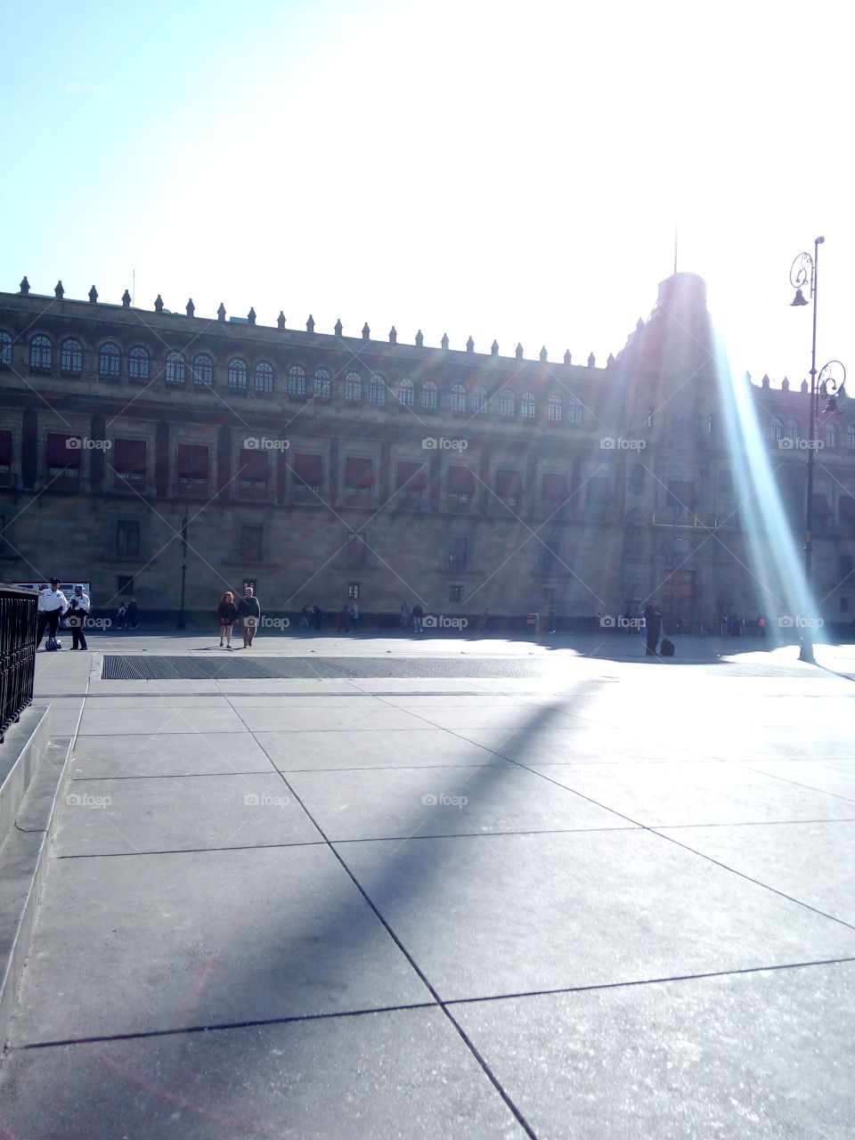 palacio nacional de México con el sol apenas saliendo en el horizonte por detrás del edificio.