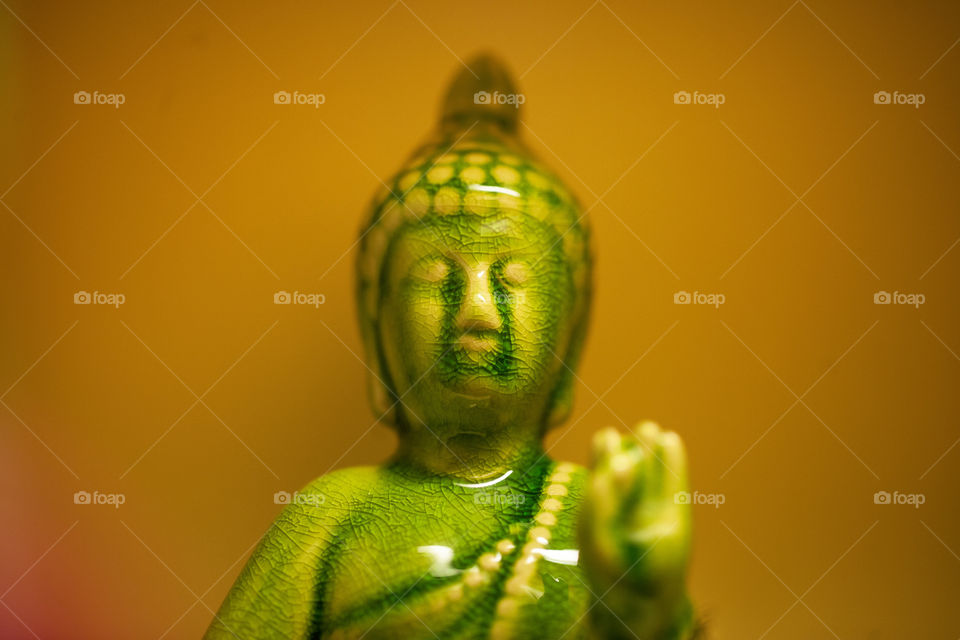 Bright green Buddha is the focus against a deep golden background with a message that all is well. Namaste. 