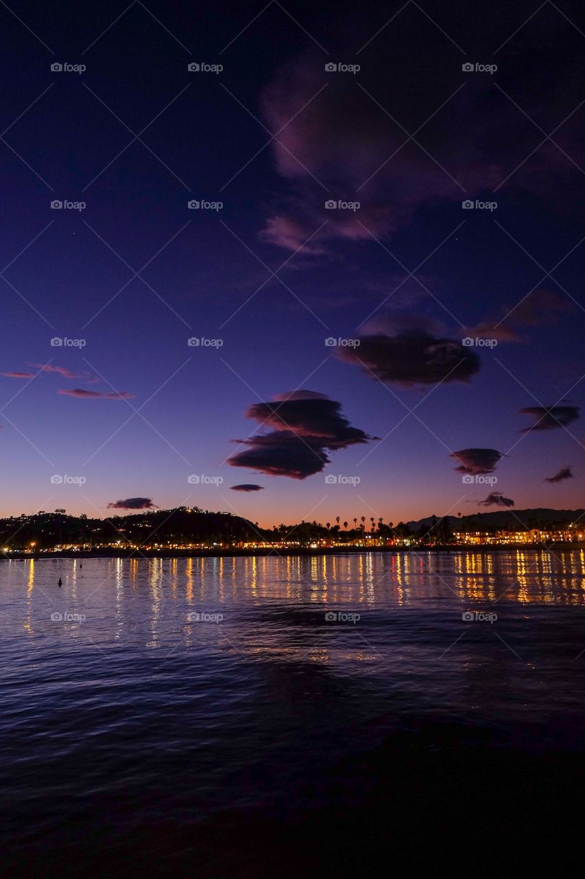 Tufts of clouds in a purple evening sky.