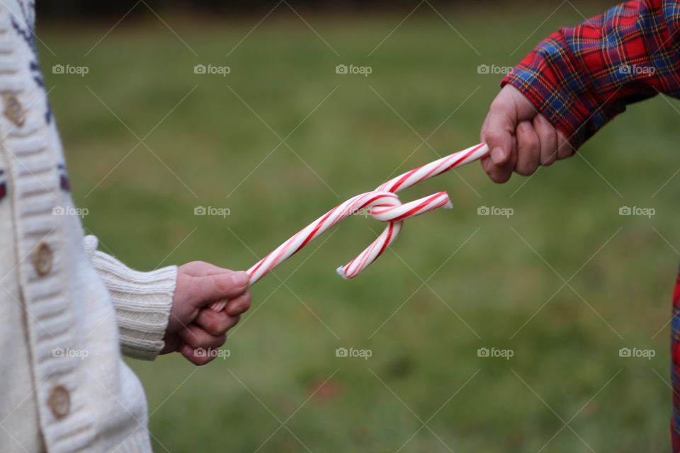 Hands holding candy canes 