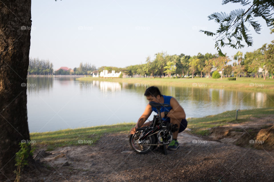 Man fixing the bike in the park 