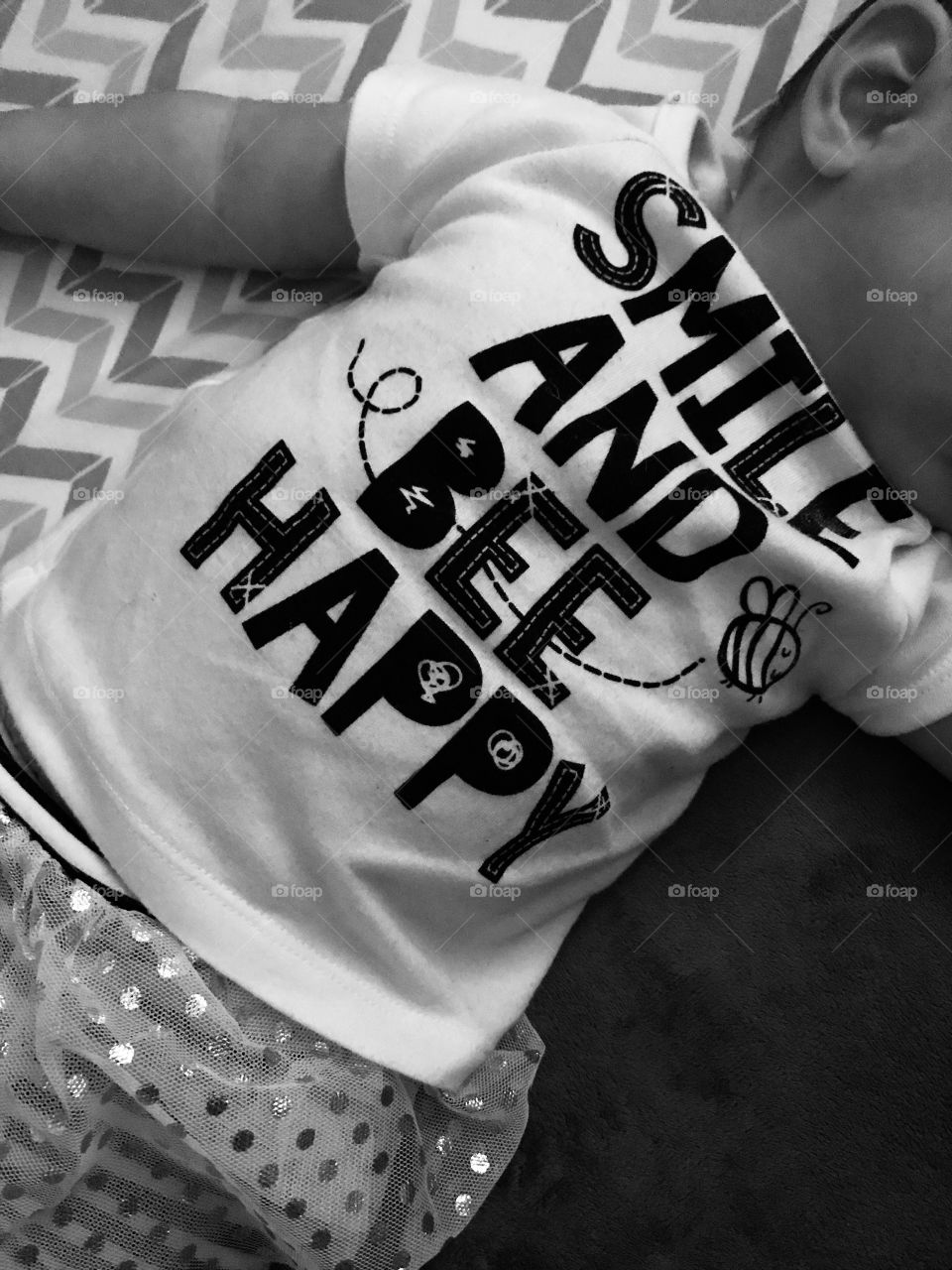 Baby with a t-shirt stating ‘smile and bee happy’