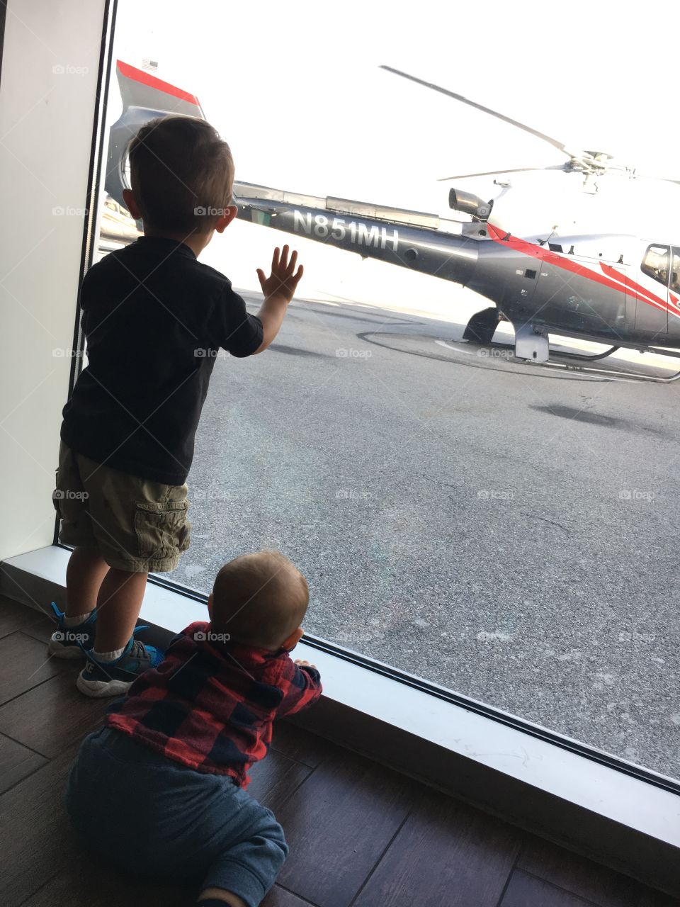 Two Toddler Boys watching a helicopter 