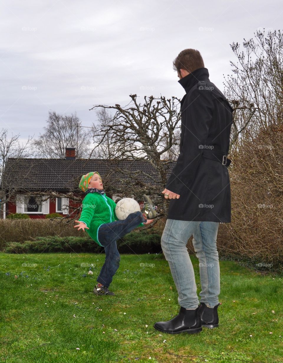 Father and son in garden with football