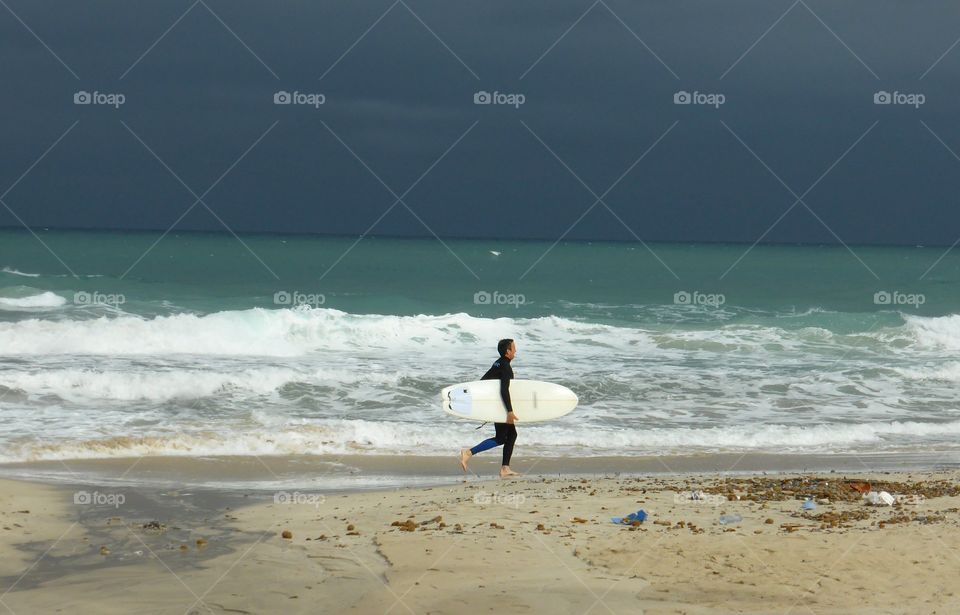 surfer walking on the beach