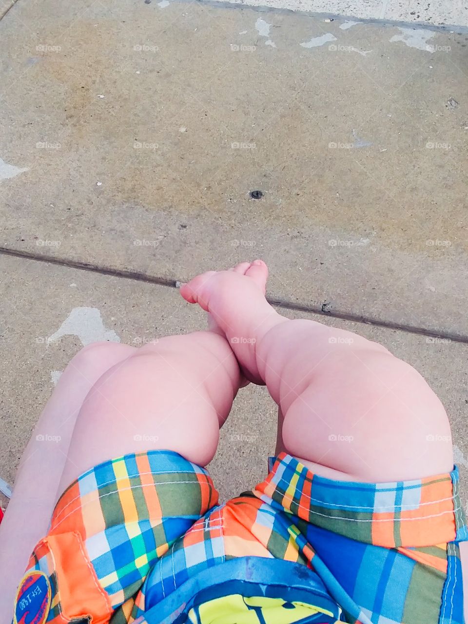 Bebé adorable enseñando sus piernas en la alberca