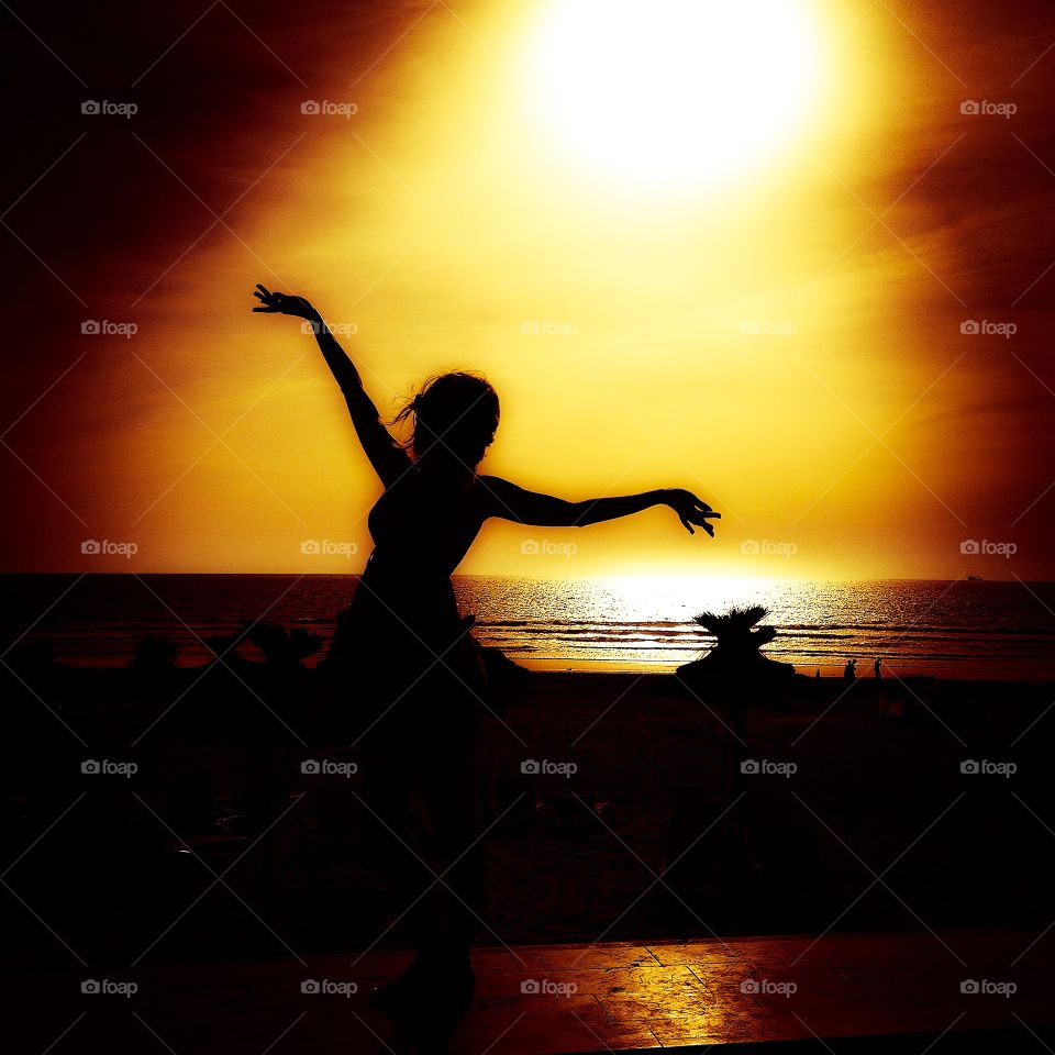 Like a seagull. A young woman walking by the beach in the evening 