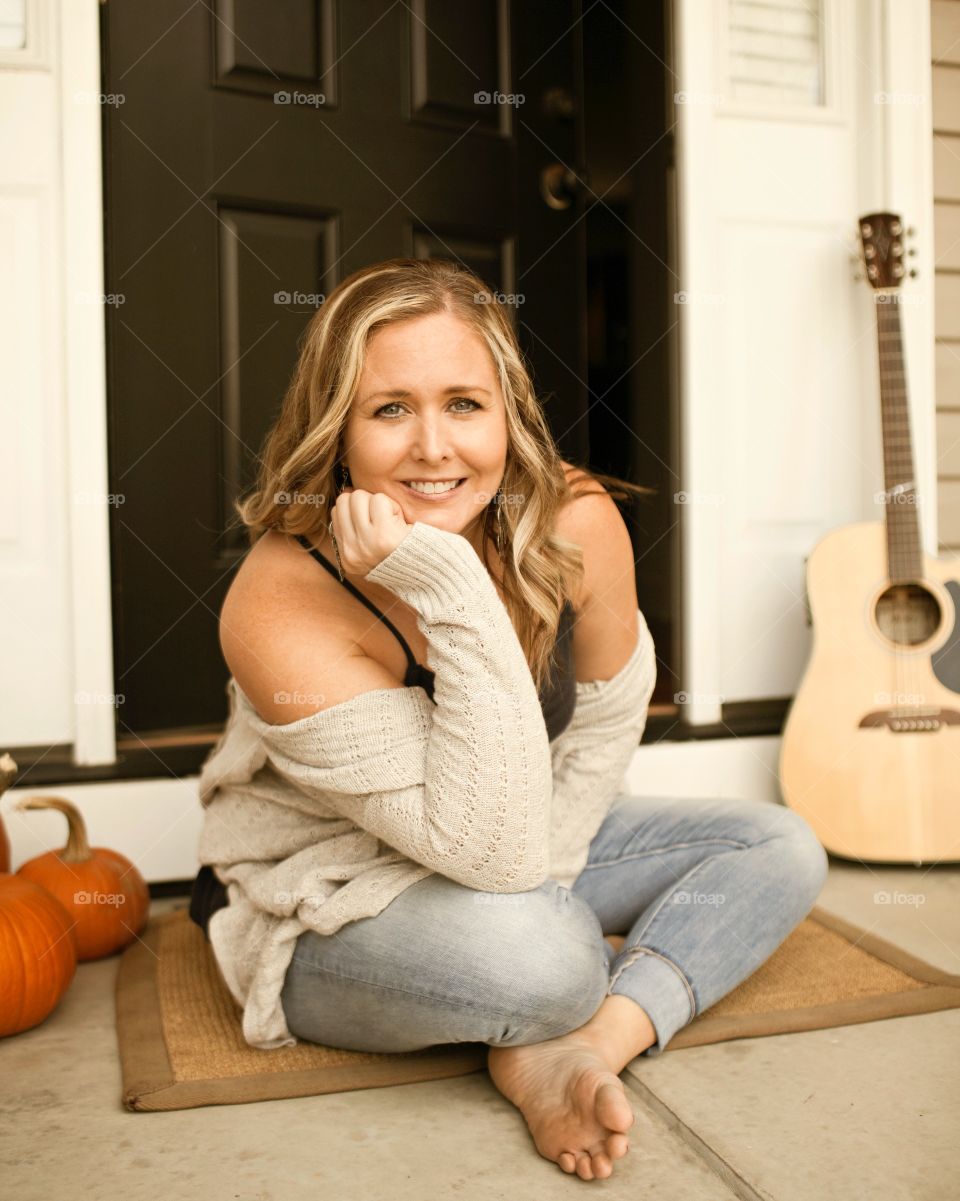 Portrait of a Beautiful woman on porch with guitar